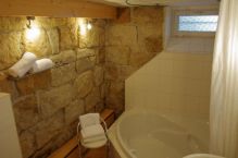 Bad mit romantischer Sandsteinwand und grosser Badewanne